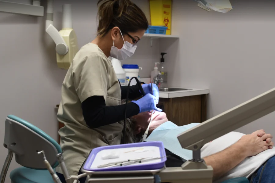 dental hygienist cleaning a patients teeth