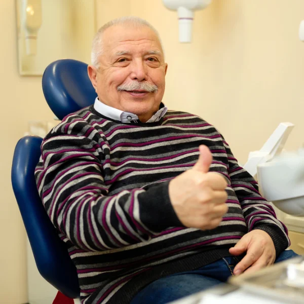 seniors-dental senior man giving a thumbs up in the dental chair